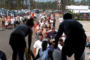 Hulpverleners delen zakken met ijs uit in Biloxi, Mississippi.