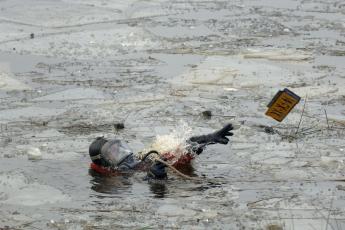 Een duiker vist een nummerplaat uit een meer.