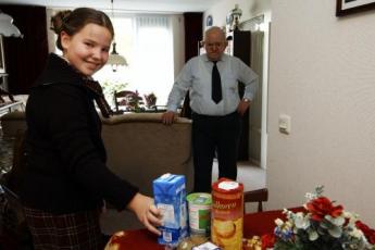 Elisabeth Bolier helpt in 't Achterdorp een oudere meneer.