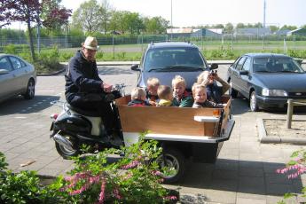OOSTERLAND – M. Goudzwaard met zijn bakscooter. In de bak zes kleinkinderen, met wie hij in de zomermaanden regelmatig lange tochten door de Zeeuwse polders maakt.